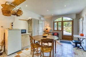 a kitchen with a table and chairs and a refrigerator at Petite Suite Douillette - Suite in Saint-Pargoire
