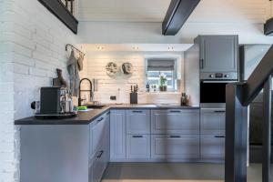 a kitchen with white appliances and a brick wall at Loft32 in Nordstrand