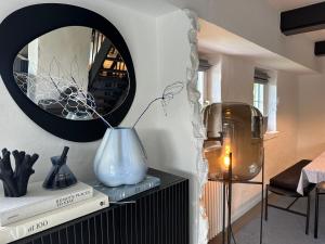 a vase on a shelf in a room with a mirror at Loft32 in Nordstrand