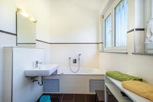a bathroom with a sink and a bath tub at Ferienwohnung Buchmann in Deggenhausertal +63 photos