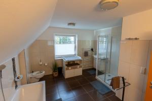 a bathroom with a toilet and a sink and a shower at Ferienhaus Ferienhof Behnke in Heringsdorf +17 photos