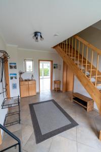 a living room with a staircase and a rug at Ferienhaus Ferienhof Behnke in Heringsdorf