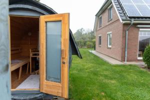 a small house with a glass door in a yard at Ferienhaus Ferienhof Behnke in Heringsdorf