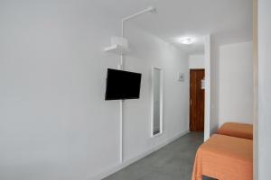 a room with a bed and a tv on a wall at Estudio Yumbo Playa in San Bartolomé