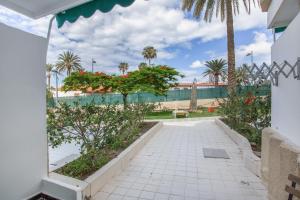 a courtyard with palm trees and a building at Estudio Yumbo Playa in San Bartolomé