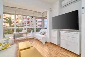 a living room with a large flat screen tv at Estudio Lighthouse F77 A109 in Torrox Costa +18 photos