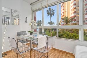 a dining room with a table and chairs and windows at Estudio Lighthouse F77 A109 in Torrox Costa
