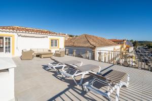 a deck with chairs and tables on a house at Apartamento Karolvaz V in Silves