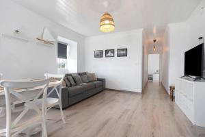 a living room with a couch and a table and a television at Casa Branca in Ribeiras