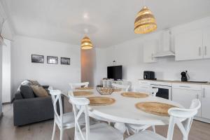 a kitchen and dining room with a white table and chairs at Casa Branca in Ribeiras