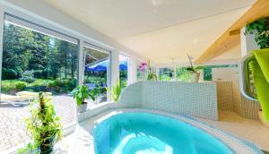 a swimming pool in a house with a large window at Ferienhotel Mühlleithen in Klingenthal