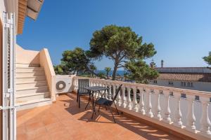 a balcony of a house with a table and chairs at Poiso da Águia in Carvoeiro