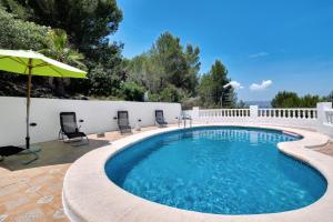 a swimming pool with chairs and an umbrella at Tossal Gros in La Font D´En Carròs