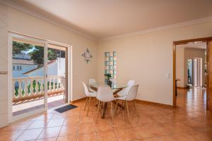 a dining room with a table and chairs and a balcony at Poiso da Águia in Carvoeiro