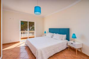 a bedroom with a large bed with a blue headboard at Poiso da Águia in Carvoeiro +33 photos