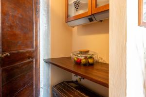 a bowl of fruit on a wooden shelf in a kitchen at La casa della Guglia in Monte San Savino +22 photos