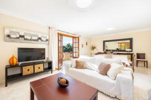 a living room with a white couch and a tv at Can Navarro in Port de Soller
