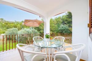 a patio with a glass table and chairs on a balcony at Can Navarro in Port de Soller