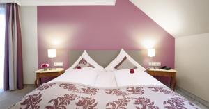 a bedroom with a large bed with a purple wall at Hotel Restaurant Paradeismühle in Klingenberg am Main +23 photos