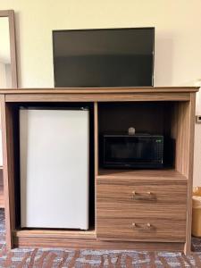 a entertainment center with a tv and a microwave at Regency Inn & Suites in Nashville