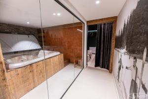 a bathroom with a bath tub and a toilet at Chalet Azureva Sauna, Jacuzzi, Spa in Levassaix