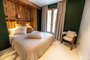 a bedroom with a bed and a chair and a window at Chalet Azureva Sauna, Jacuzzi, Spa in Levassaix