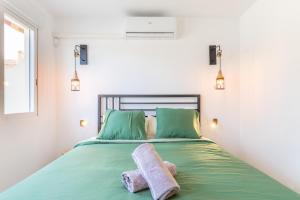 a bedroom with a green bed with towels on it at Sol y Sombra in El Campello +20 photos