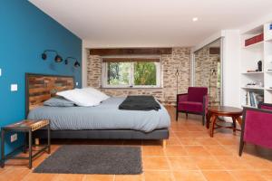 a bedroom with a bed and a blue wall at La Longère d'Arzoù Chambres D'hôtes in Baden