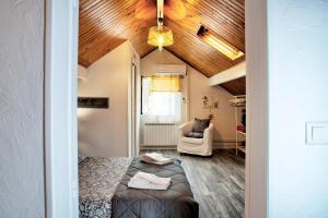 a bedroom with a bed and a chair in a room at Chambre D'hotes Les Tuilières in Mouleydier