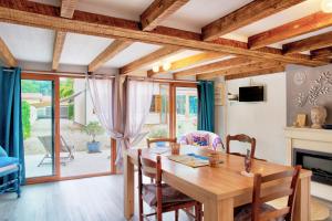 a dining room with a table and chairs and a fireplace at Chambre D'hotes Les Tuilières in Mouleydier