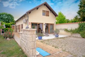 a house with a stone wall and a yard at Chambre D'hotes Les Tuilières in Mouleydier