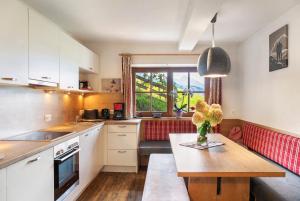 a kitchen with white cabinets and a table with flowers on it at Oberlehen Hof in Rohrberg