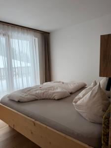 a bed sitting in a room with a window at Ladinser Hof Kuschelecke in Castelrotto