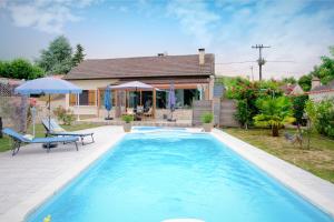a swimming pool in front of a house at Chambre D'hotes Les Tuilières in Mouleydier