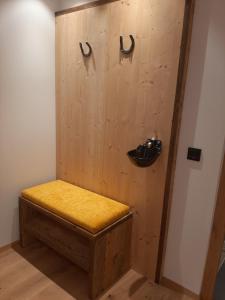 a bench in a room with a wooden wall at Ladinser Hof Kuschelecke in Castelrotto