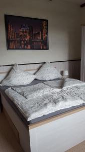 a large white bed with a picture on the wall at Fewo einzigartige Aussicht im Harz in Walkenried