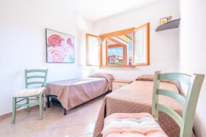 a room with two beds and a table and chairs at A.I.R. Isola Rossa Borgo di Mare in Isola Rossa +129 photos