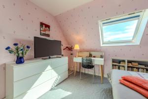 a bedroom with pink walls and a flat screen tv at Chambre d'hôtes à Lesneven in Lesneven