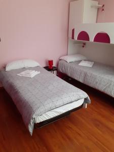 a bedroom with two beds and a wooden floor at La Casa di Aldo 15 minuti da Torino in Pecetto