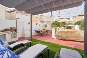 a patio with a table and chairs on the grass at Casa Victoria G in Nerja