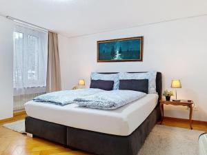 a bedroom with a large bed with blue pillows at Apartment Bieri-Haus by Interhome in Unterseen