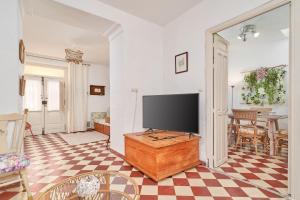 a living room with a flat screen tv on a wooden table at Casa Victoria G in Nerja