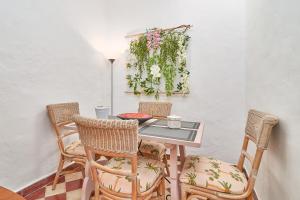 a table and chairs with flowers on a wall at Casa Victoria G in Nerja
