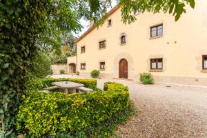 a garden with a table in front of a building at Rural Mas Vila in Fogás de Tordera