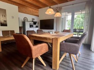 a dining room with a wooden table and chairs at Ferienhaus Marlen in Naumburg