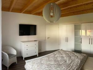 a bedroom with a bed and a tv and a chair at Ferienhaus Marlen in Naumburg