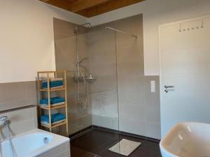 a bathroom with a shower and a tub and a sink at Ferienhaus Marlen in Naumburg +24 photos