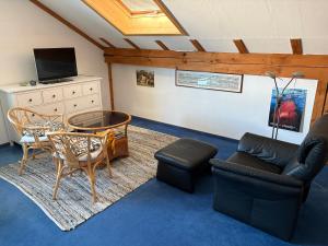 a living room with a couch and chairs and a tv at Ferienhaus Unteres Hart in Gomadingen