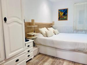 a white bedroom with a bed and a dresser at Amets in Yesa