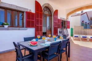 a dining room with a table and chairs and red shutters at Villa Cas Siulet in Alcudia